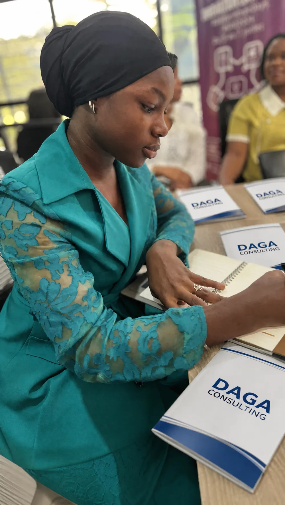Participante prenant des notes devant des brochures DAGA Consulting lors d’une séance de travail